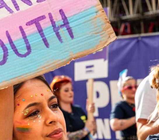 Person with banner that reads protect trans youth
