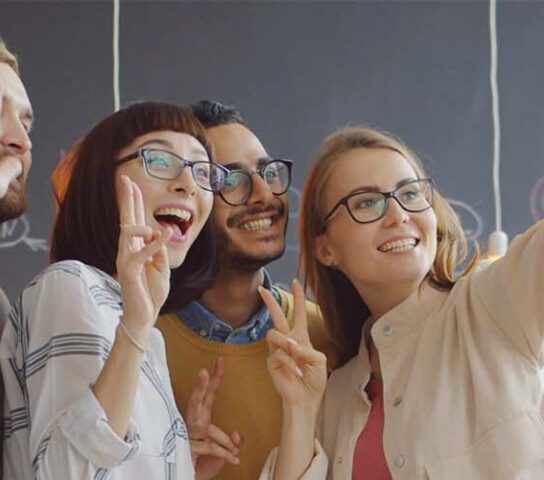Staff taking a selfie in front of a blackboard