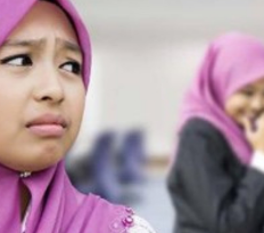 A young person in a hijab looking unhappy.