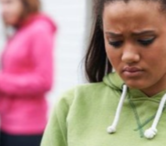 A young person on their phone looking unhappy.