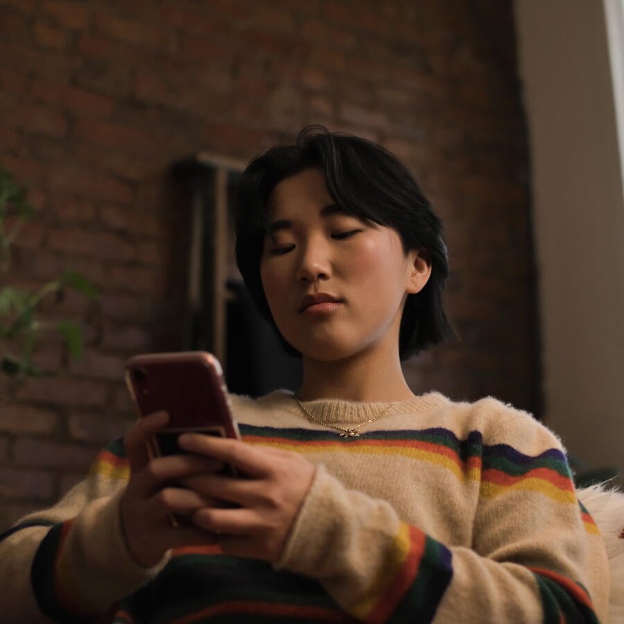 A non binary person looking at a cellphone 1