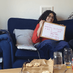 Person holding up a whiteboard with words on it
