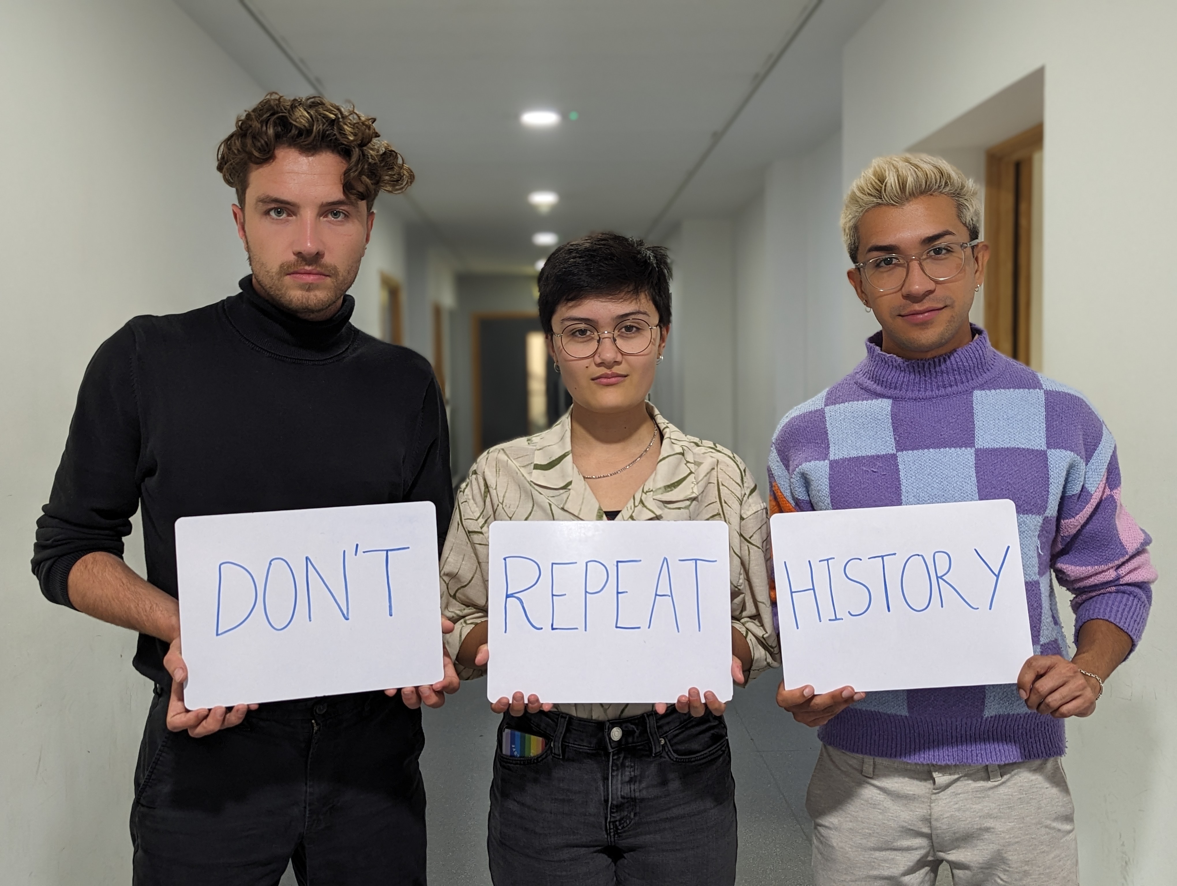 Three people holding whiteboards with a word written on each. 'Don't 'Repeat' 'History'