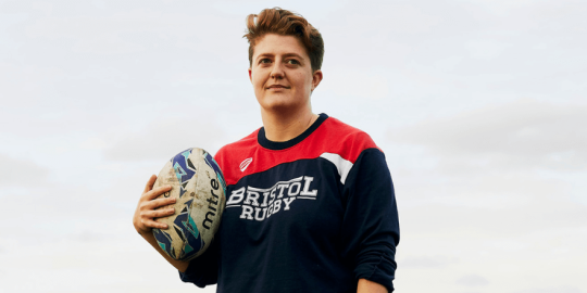 person holding a rugby ball outside