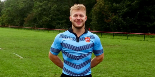 Person in a rugby uniform in a field