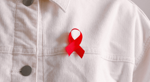 Red ribbon pinned to a white shirt