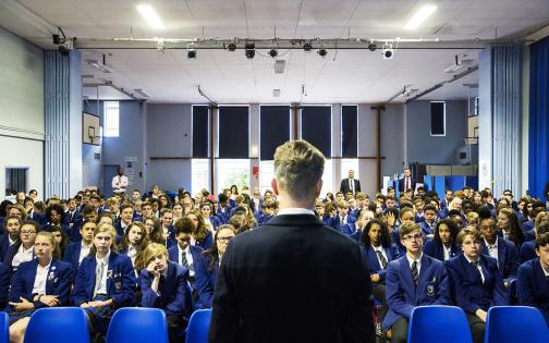Teacher standing in front of school assembly