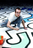 Keith Haring crouched on the floor creating a huge artwork